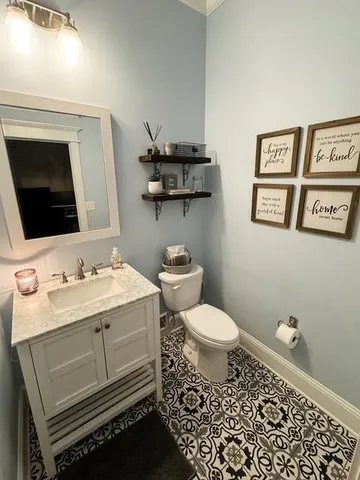 a bathroom with a granite countertop toilet sink and mirror