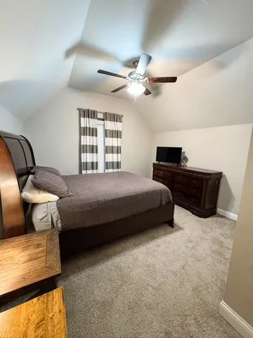 a bedroom with a bed and a large mirror