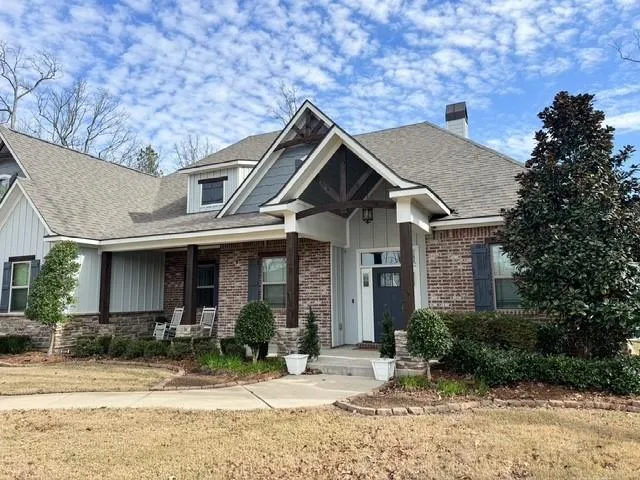 a front view of a house with a yard and potted plants