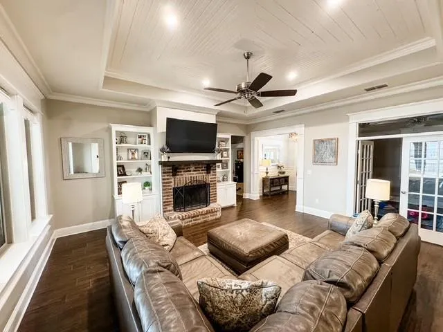 a living room with furniture a fireplace and a flat screen tv