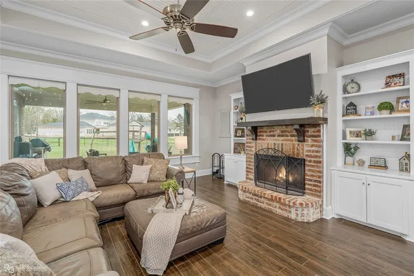 a living room with furniture a flat screen tv and a fireplace