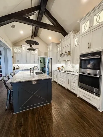 a kitchen with stainless steel appliances kitchen island granite countertop a stove a sink and a microwave