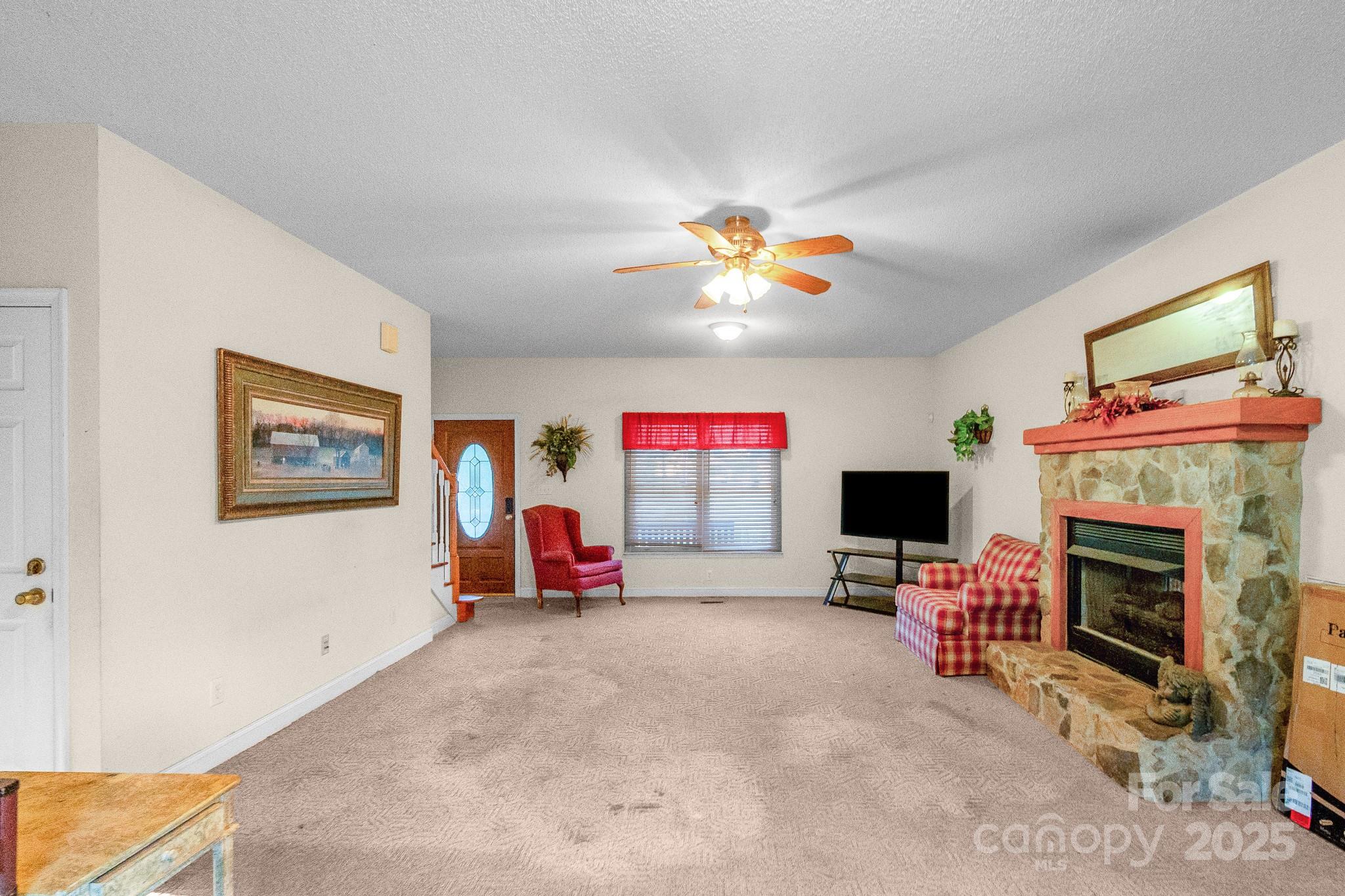 2775 State Rd S-29-285 Lancaster, SC 29720 - Photo 15 of 48 a view of a livingroom with a fireplace a ceiling fan and a window