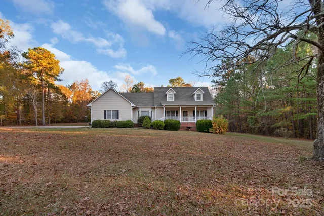 a front view of a house with a yard and trees