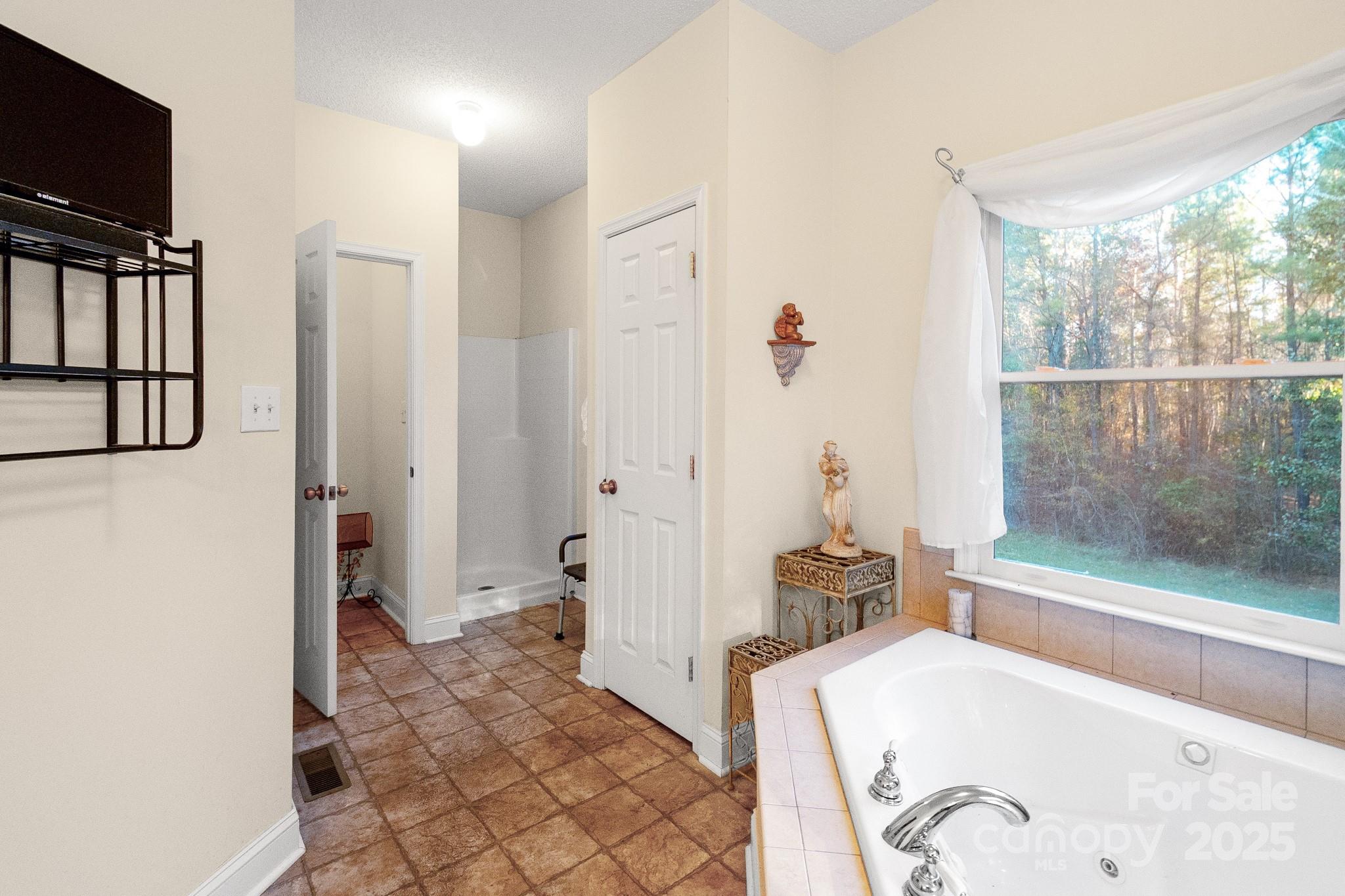 2775 State Rd S-29-285 Lancaster, SC 29720 - Photo 38 of 48 a bathroom with a tub a mirror and a shower
