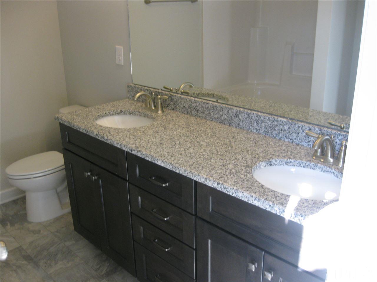 8013 Creech Road Middlesex, NC 27557 - Photo 11 of 11 a bathroom with a granite countertop sink a toilet and a mirror