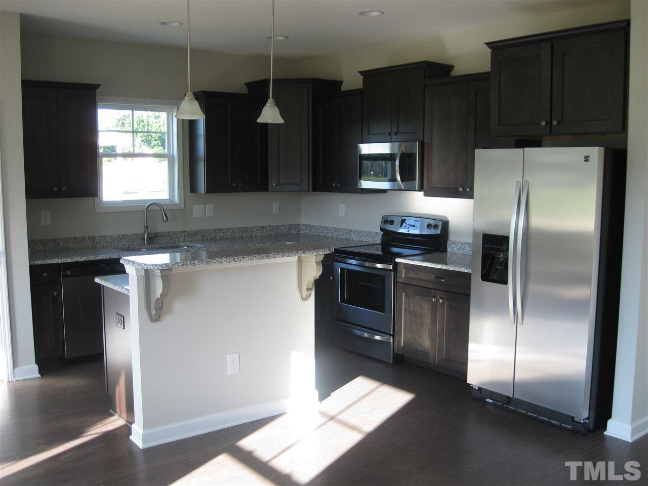 8013 Creech Road Middlesex, NC 27557 - Photo 6 of 11 a kitchen with granite countertop a refrigerator and a stove top oven
