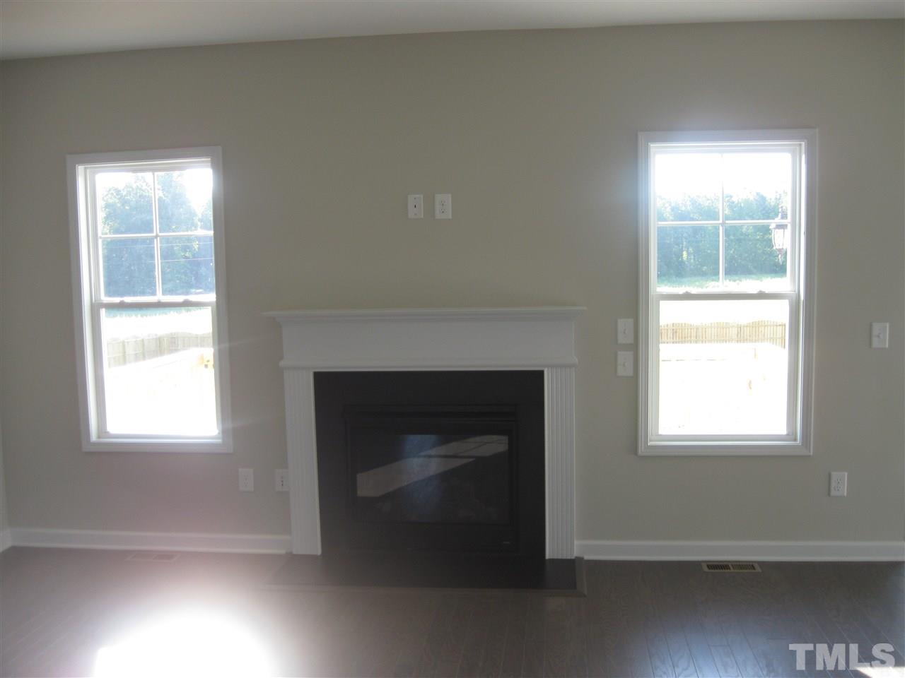 8013 Creech Road Middlesex, NC 27557 - Photo 8 of 11 an empty room with a fireplace and windows