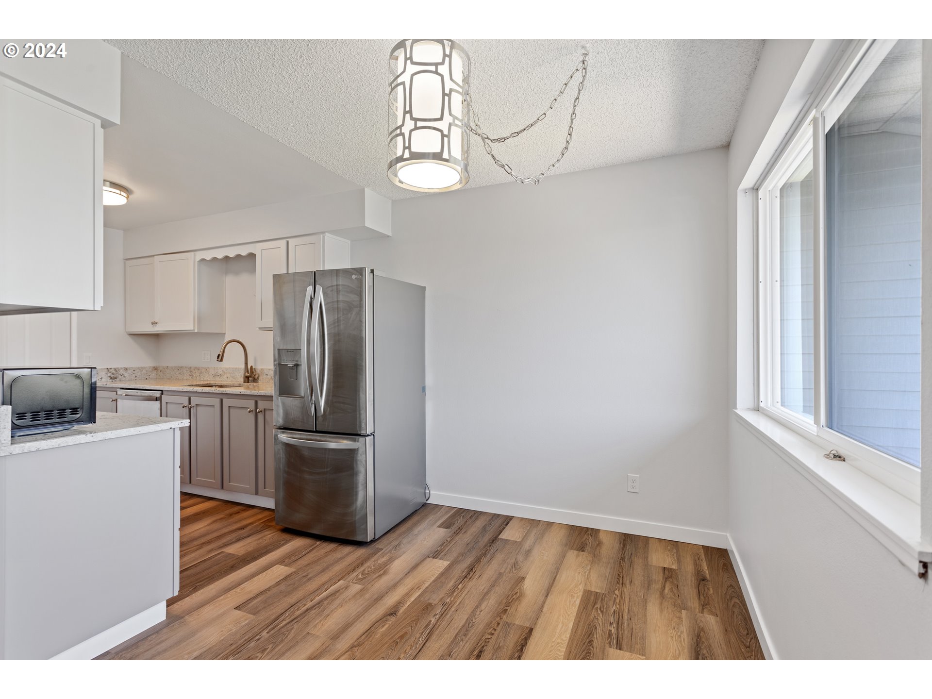950 Evergreen Road, Unit 316 Woodburn, OR 97071 - Photo 8 of 38 a kitchen with cabinets wooden floor and stainless steel appliances