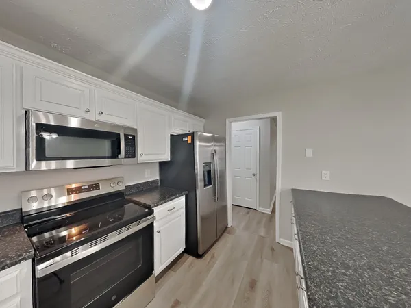 a kitchen with stainless steel appliances a stove microwave and a refrigerator