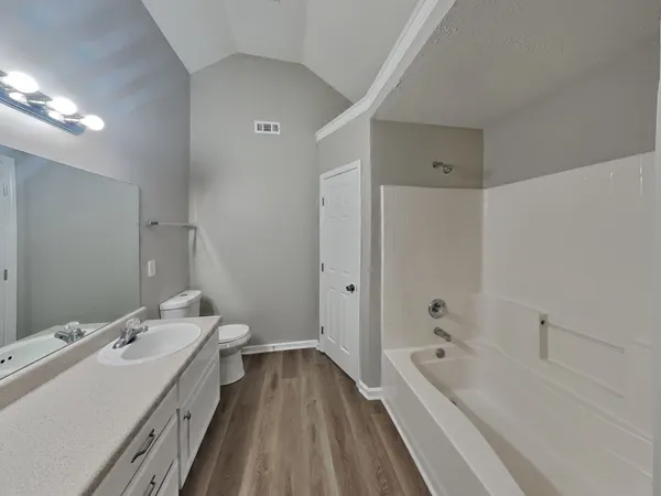 a bathroom with a tub sink and mirror