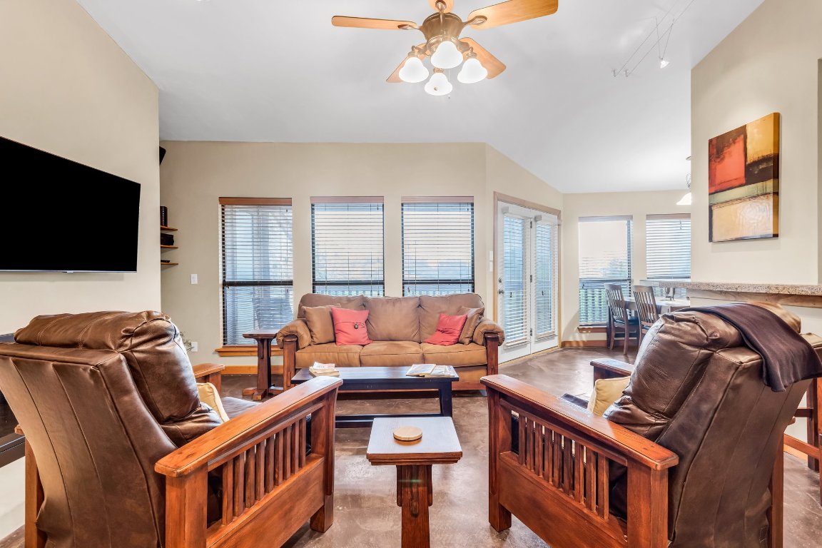 a living room with furniture a flat screen tv and a window