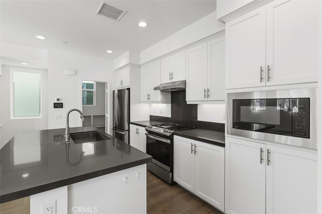 109 Mirth Irvine, CA 92618 - Photo 10 of 43 a kitchen with stainless steel appliances granite countertop a sink a stove a microwave and cabinets