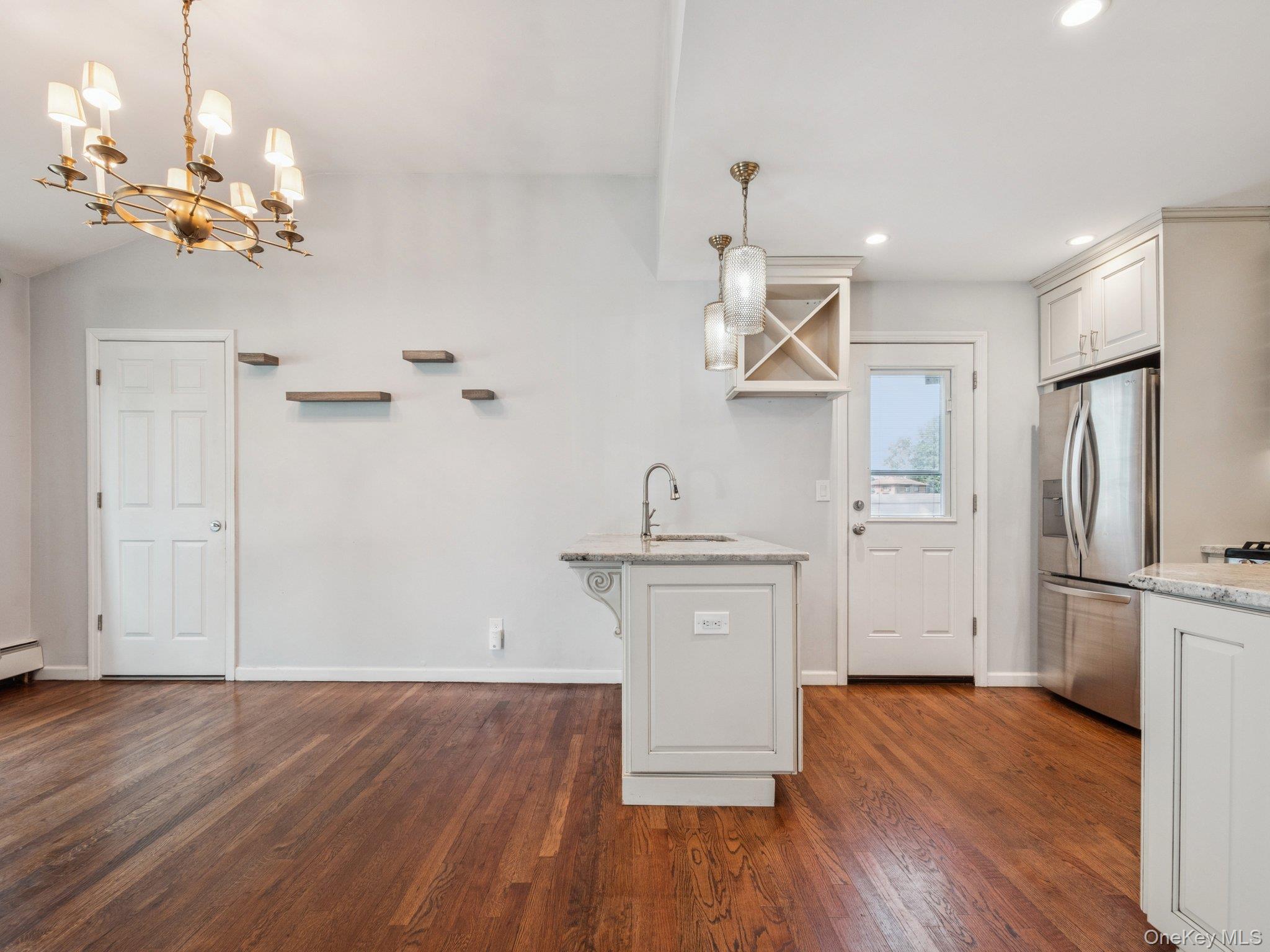 247 Woods Road North Babylon, NY 11703 - Photo 12 of 43 a kitchen with stainless steel appliances granite countertop a refrigerator a sink dishwasher a stove and white cabinets with wooden floor