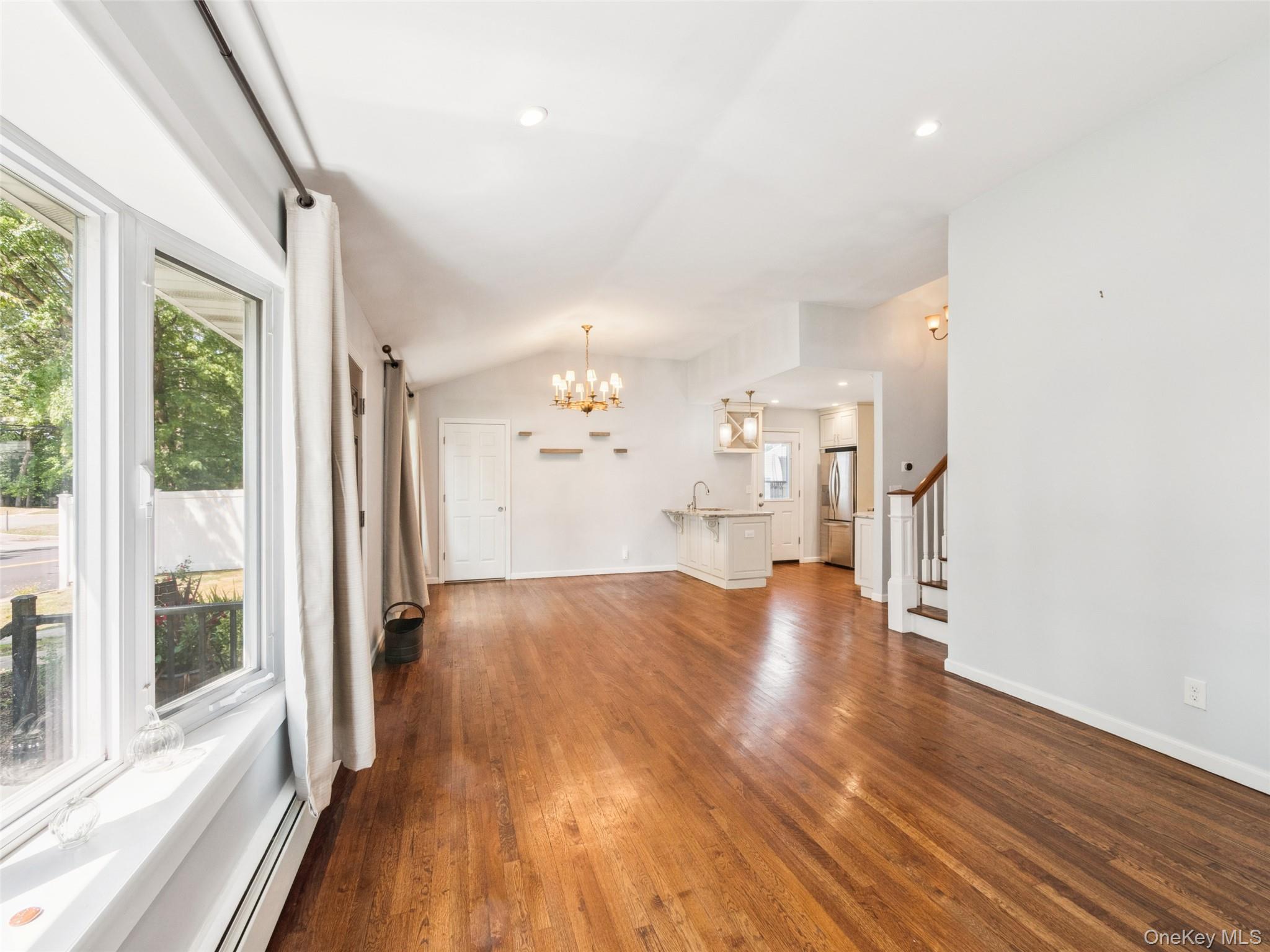 247 Woods Road North Babylon, NY 11703 - Photo 14 of 43 a view of an empty room with wooden floor and a window
