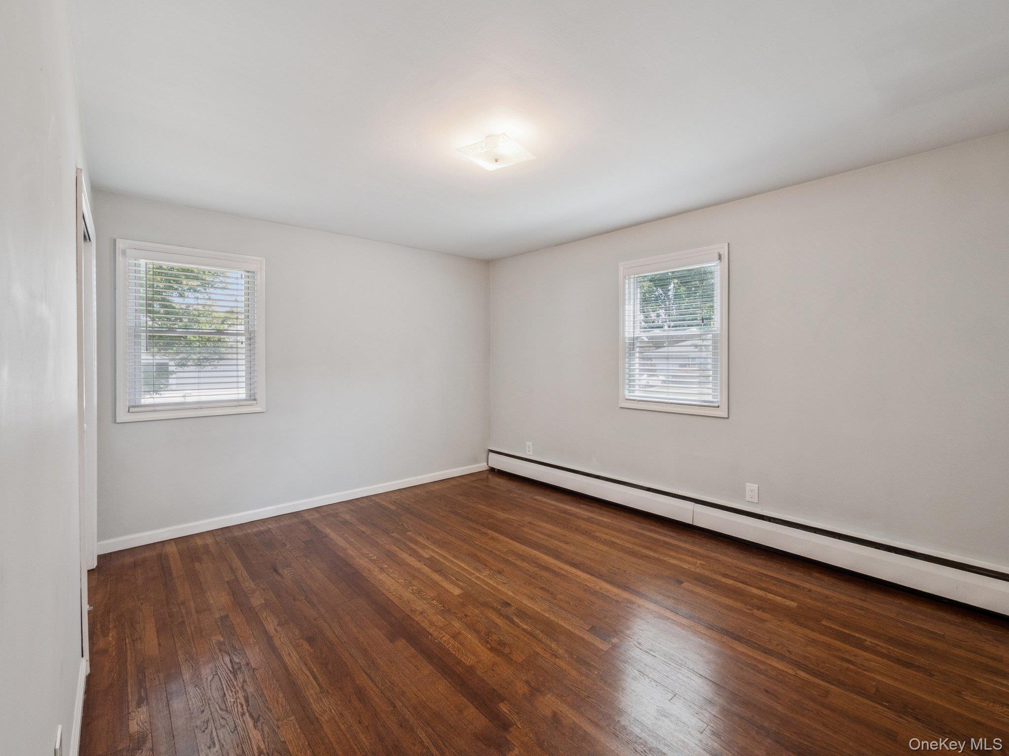 247 Woods Road North Babylon, NY 11703 - Photo 19 of 43 a view of an empty room with wooden floor and a window