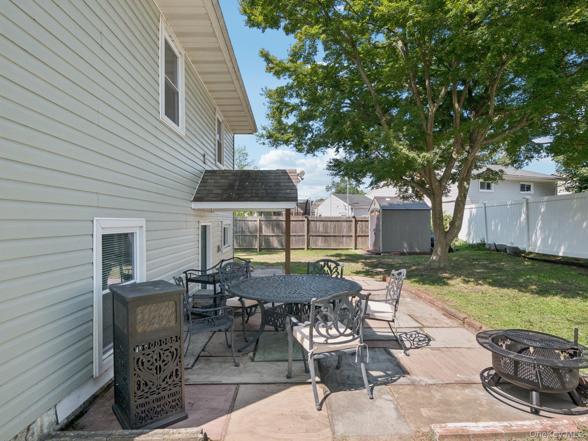 247 Woods Road North Babylon, NY 11703 - Photo 42 of 43 a view of a patio with table and chairs and potted plants