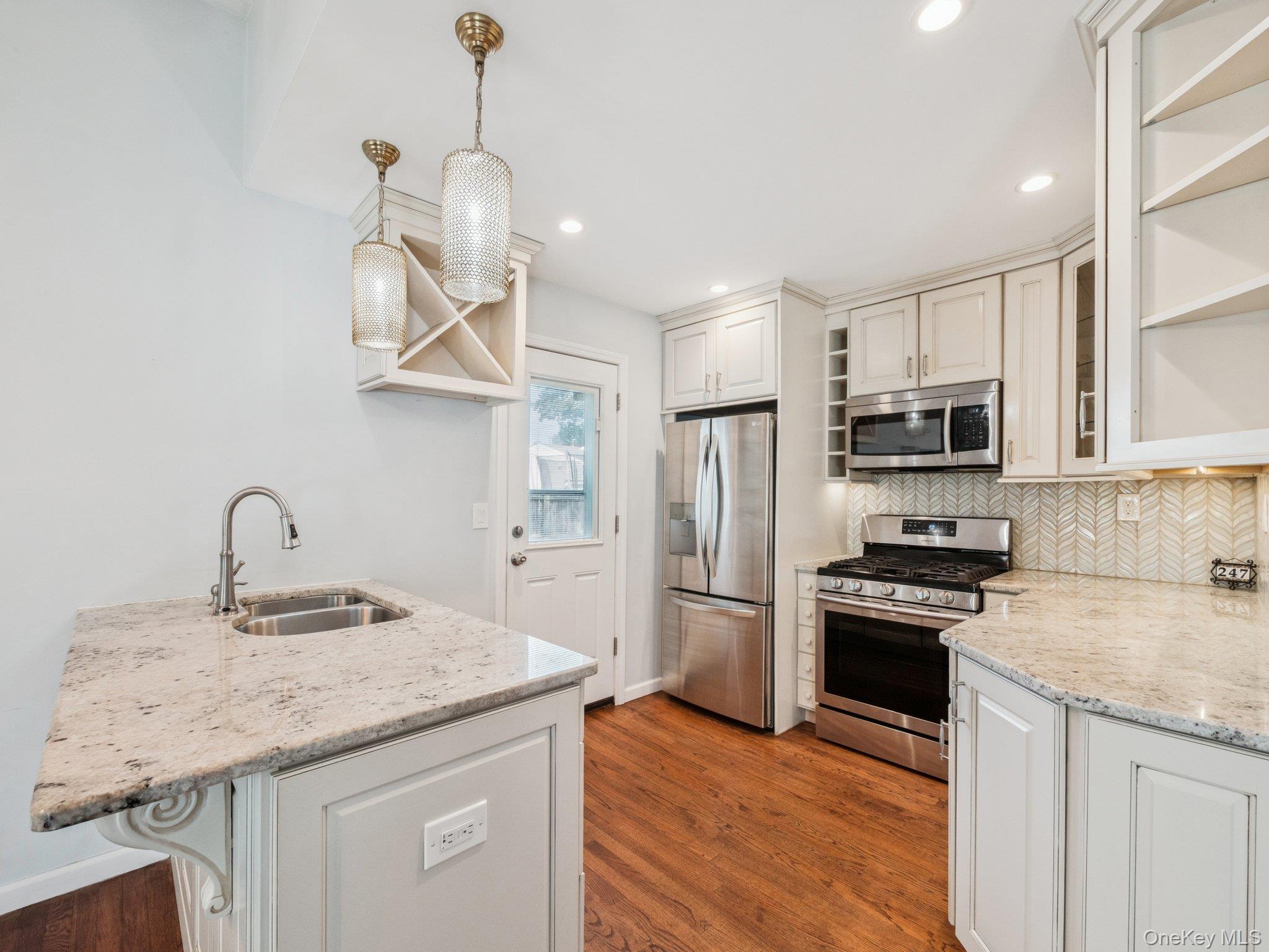 247 Woods Road North Babylon, NY 11703 - Photo 8 of 43 a kitchen with stainless steel appliances granite countertop a sink refrigerator and microwave