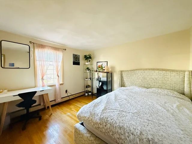 a spacious bedroom with a bed a table and a bookshelf