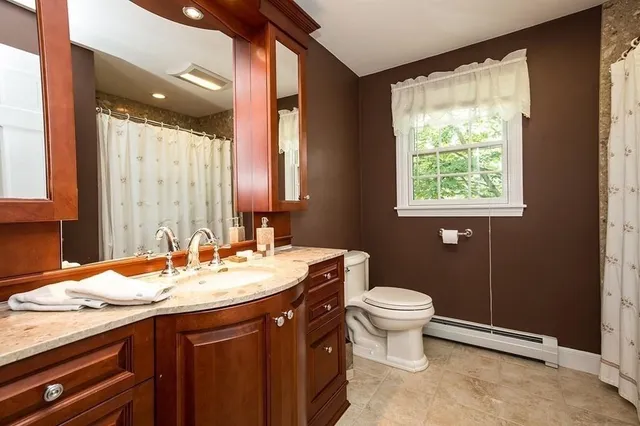 a bathroom with a granite countertop sink toilet and mirror