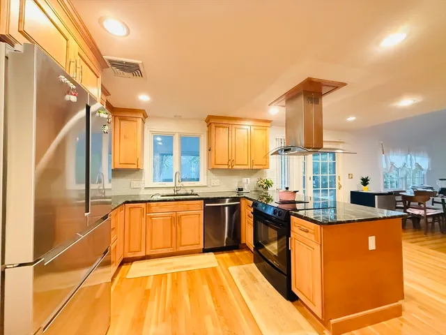 a kitchen with stainless steel appliances granite countertop sink stove and refrigerator