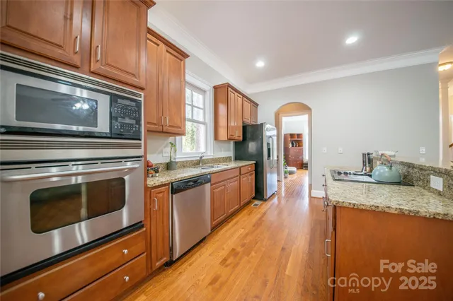 a large kitchen with granite countertop a stove and a sink