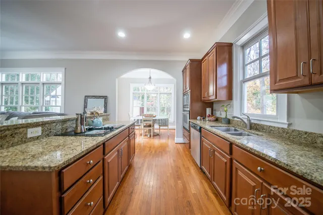 a kitchen with granite countertop a sink stove and cabinets