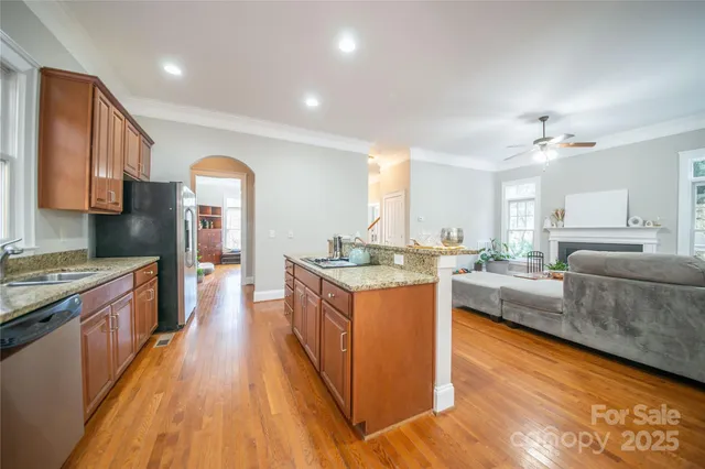 a large kitchen with stainless steel appliances granite countertop a stove and a wooden floors