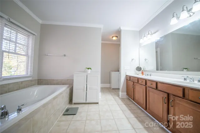 a spacious bathroom with a tub sink and mirror