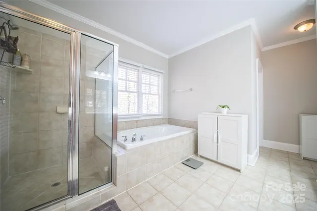 a spacious bathroom with a tub shower and window