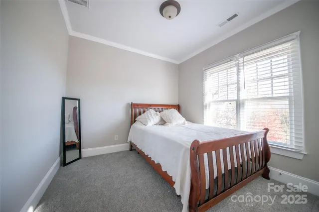 a bed sitting in a bedroom next to a window