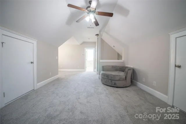 a view of an empty room and chandelier fan