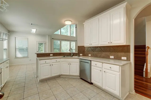a kitchen with white cabinets granite counter tops and a window