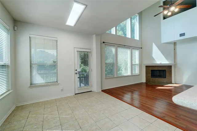 an empty room with windows and fireplace