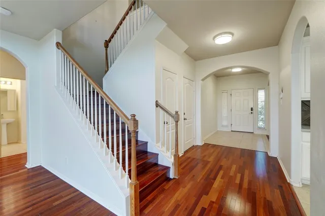 a view of a hallway with wooden floor and staircase