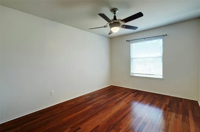 a view of a big room with wooden floor and windows