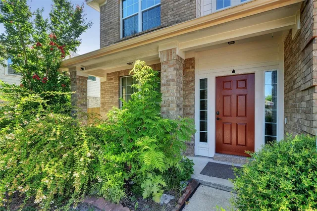 a view of a house with potted plants and a tree