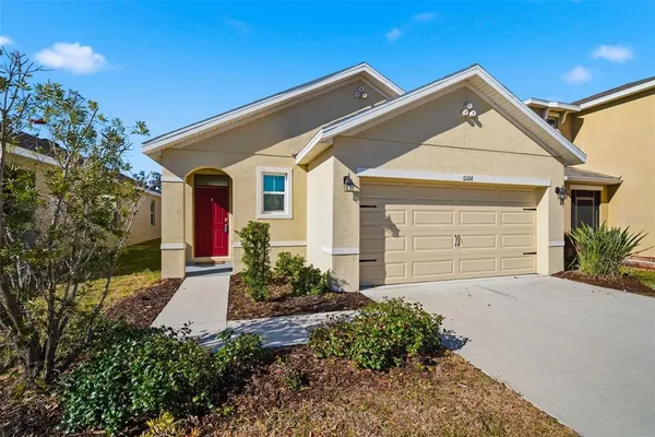 a front view of a house with a yard and garage