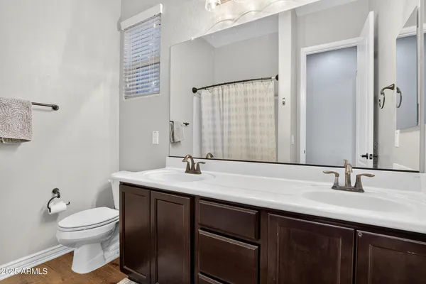 a bathroom with a granite countertop sink toilet and mirror