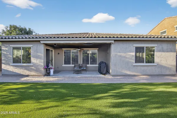 a view of a house with a patio and a yard