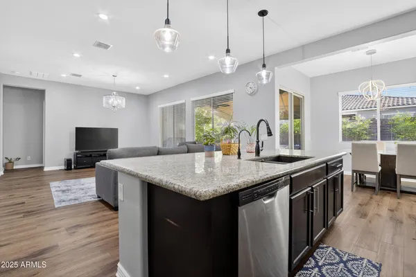 a kitchen with a center island wooden floor and a view of living room
