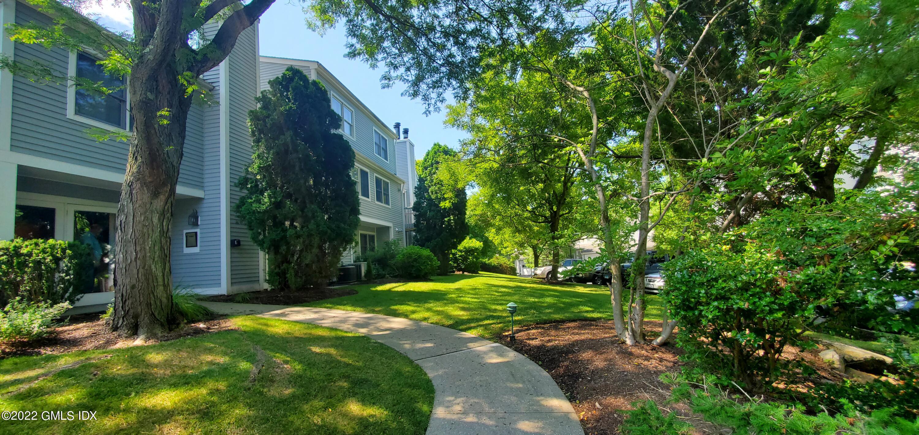 351 Pemberwick Road, Unit 821 Greenwich, CT 06831 - Photo 2 of 16 a backyard of a house with lots of green space
