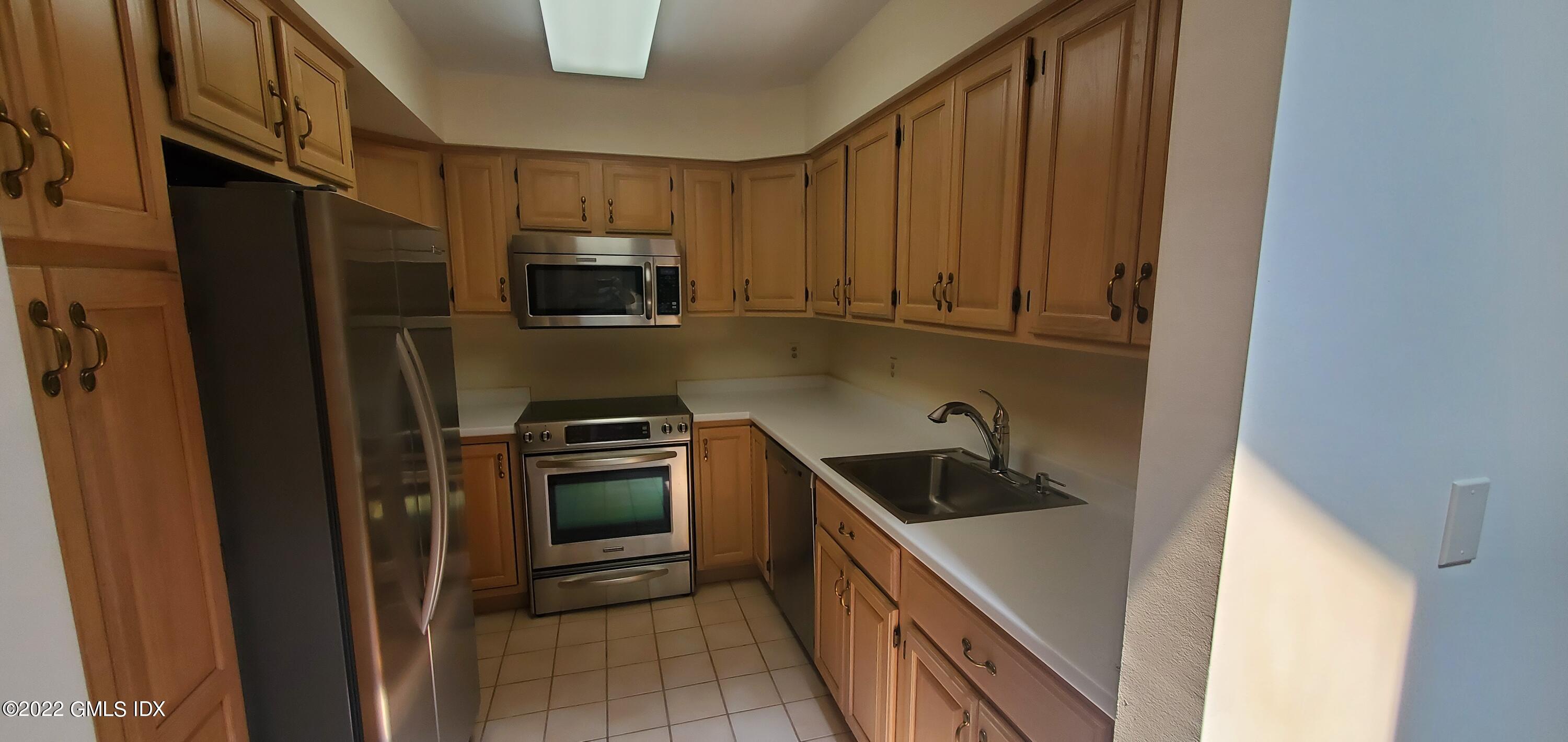 351 Pemberwick Road, Unit 821 Greenwich, CT 06831 - Photo 6 of 16 a kitchen with a refrigerator stove and microwave