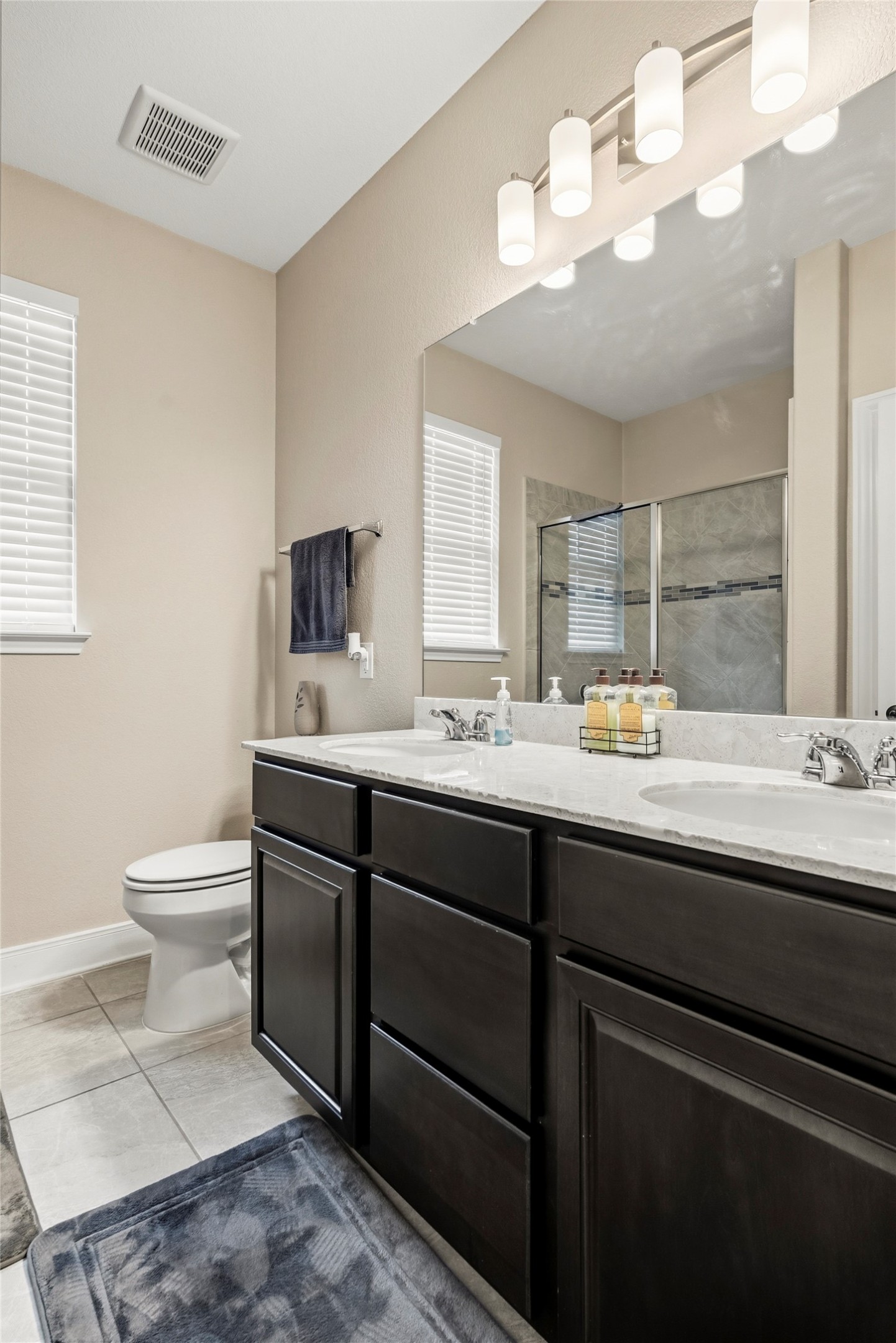 105 West Point Way Elgin, TX 78621 - Photo 24 of 27 Dual vanity with dark wood-finish cabinetry, light-toned countertops, and two integrated sinks