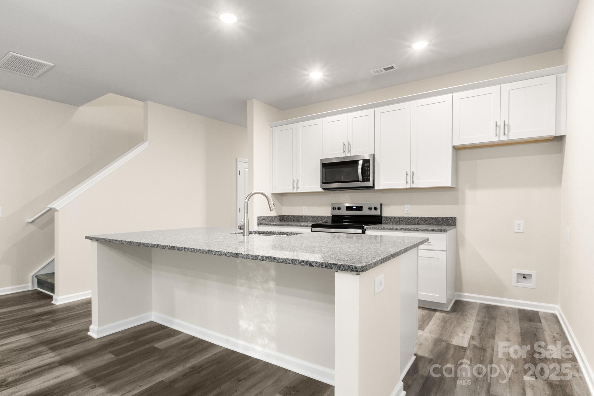 990 Shearers Road Mooresville, NC 28115 - Photo 26 of 46 a kitchen with stainless steel appliances a sink a stove a microwave and cabinets