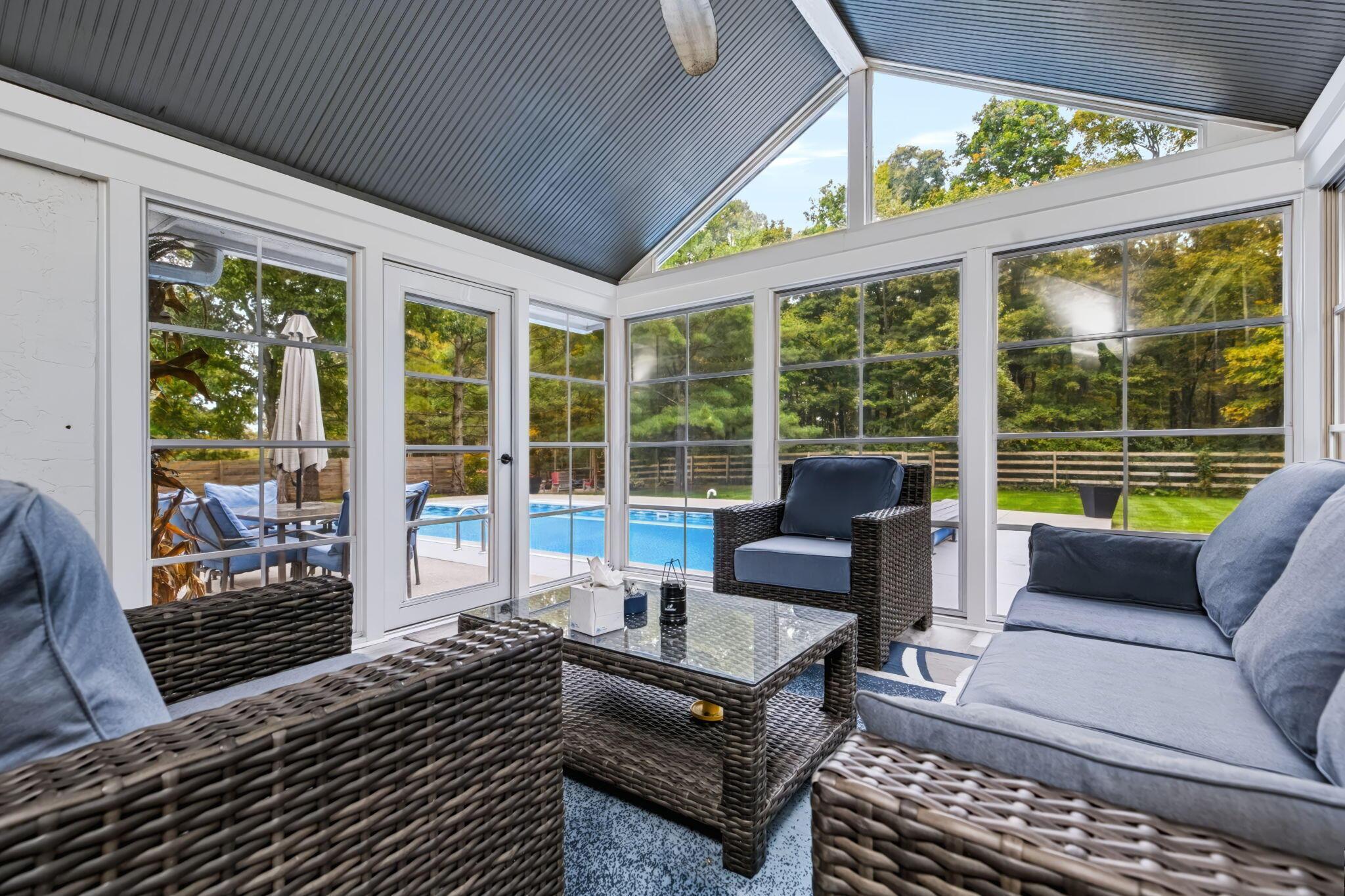 7140 Cook Road Powell, OH 43065 - Photo 64 of 87 Sunroom with expansive multi-panel glass enclosure showcasing manicured grounds and pool area beyond