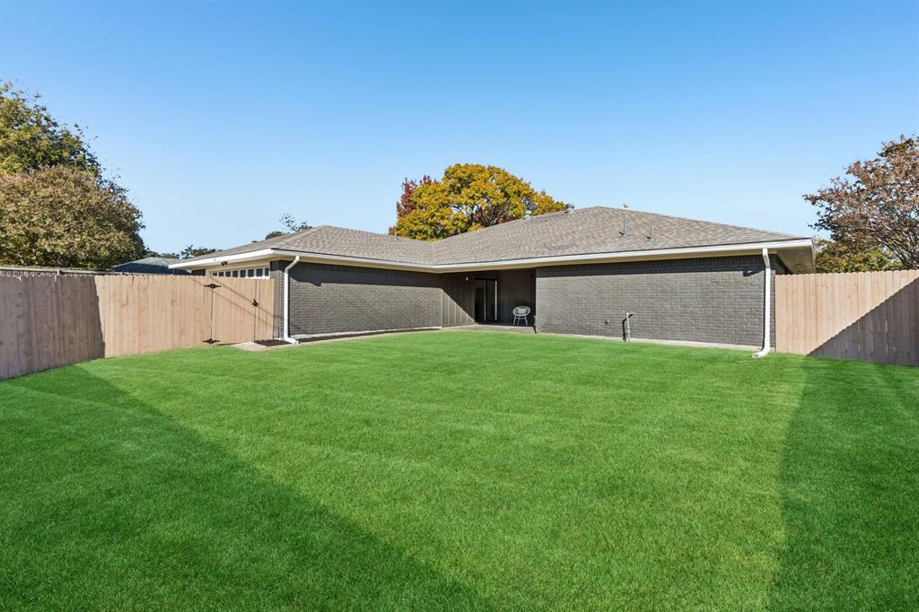 311 High Brook Drive Richardson, TX 75080 - Photo 24 of 26 Rear view of house featuring a fenced backyard, brick siding, a patio area, and roof with shingles