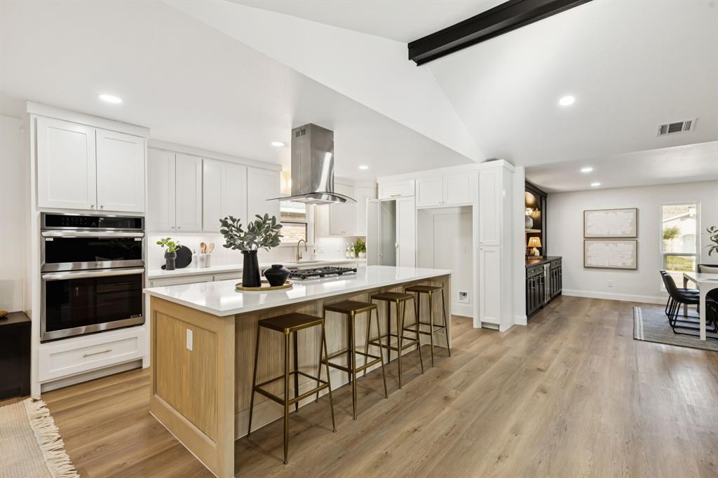 311 High Brook Drive Richardson, TX 75080 - Photo 7 of 26 Kitchen with white cabinetry, a kitchen island, stainless steel appliances, a kitchen breakfast bar, and recessed lighting