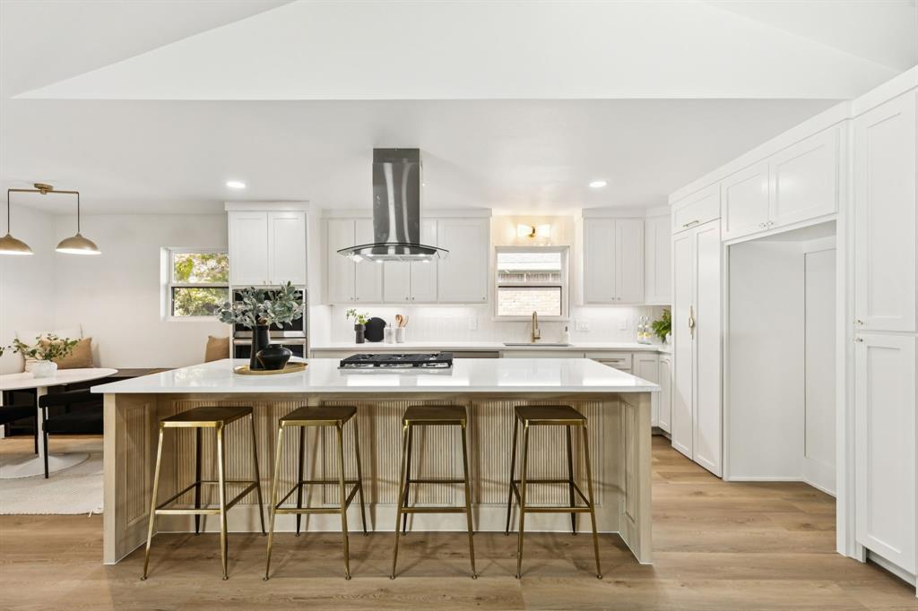 311 High Brook Drive Richardson, TX 75080 - Photo 10 of 26 Kitchen featuring a spacious island, a kitchen bar, white cabinetry, vaulted ceiling, and recessed lighting