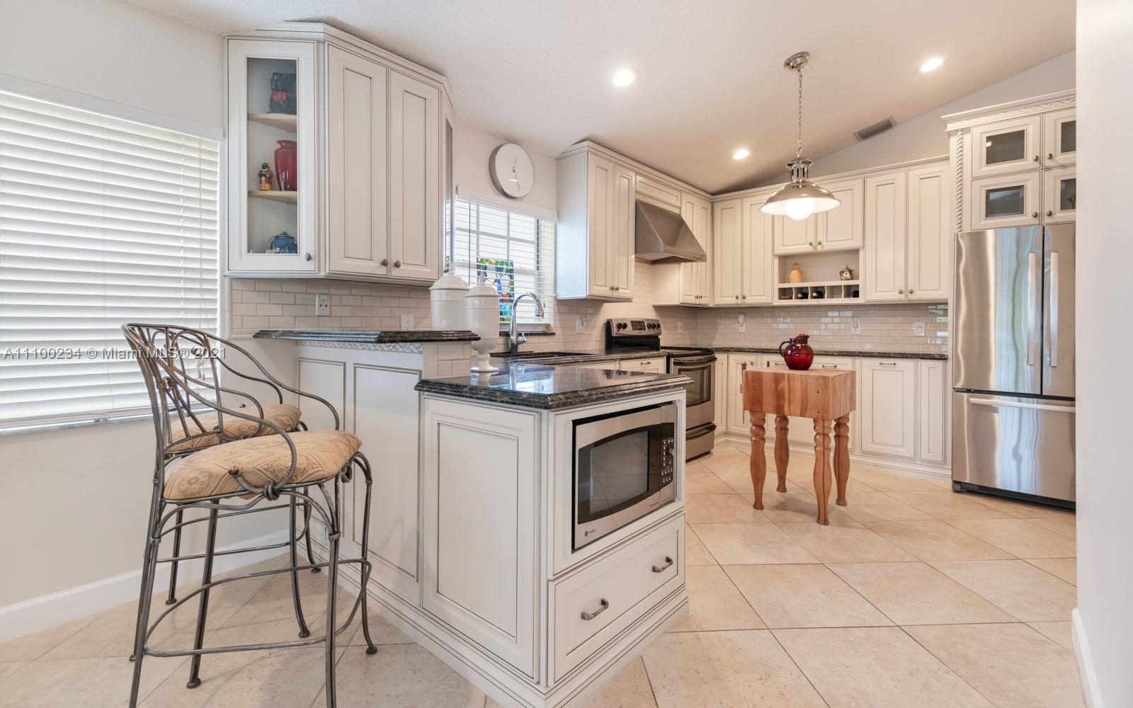 207 Cameron Court Weston, FL 33326 - Photo 11 of 35 a kitchen with stainless steel appliances granite countertop a stove a sink and a refrigerator